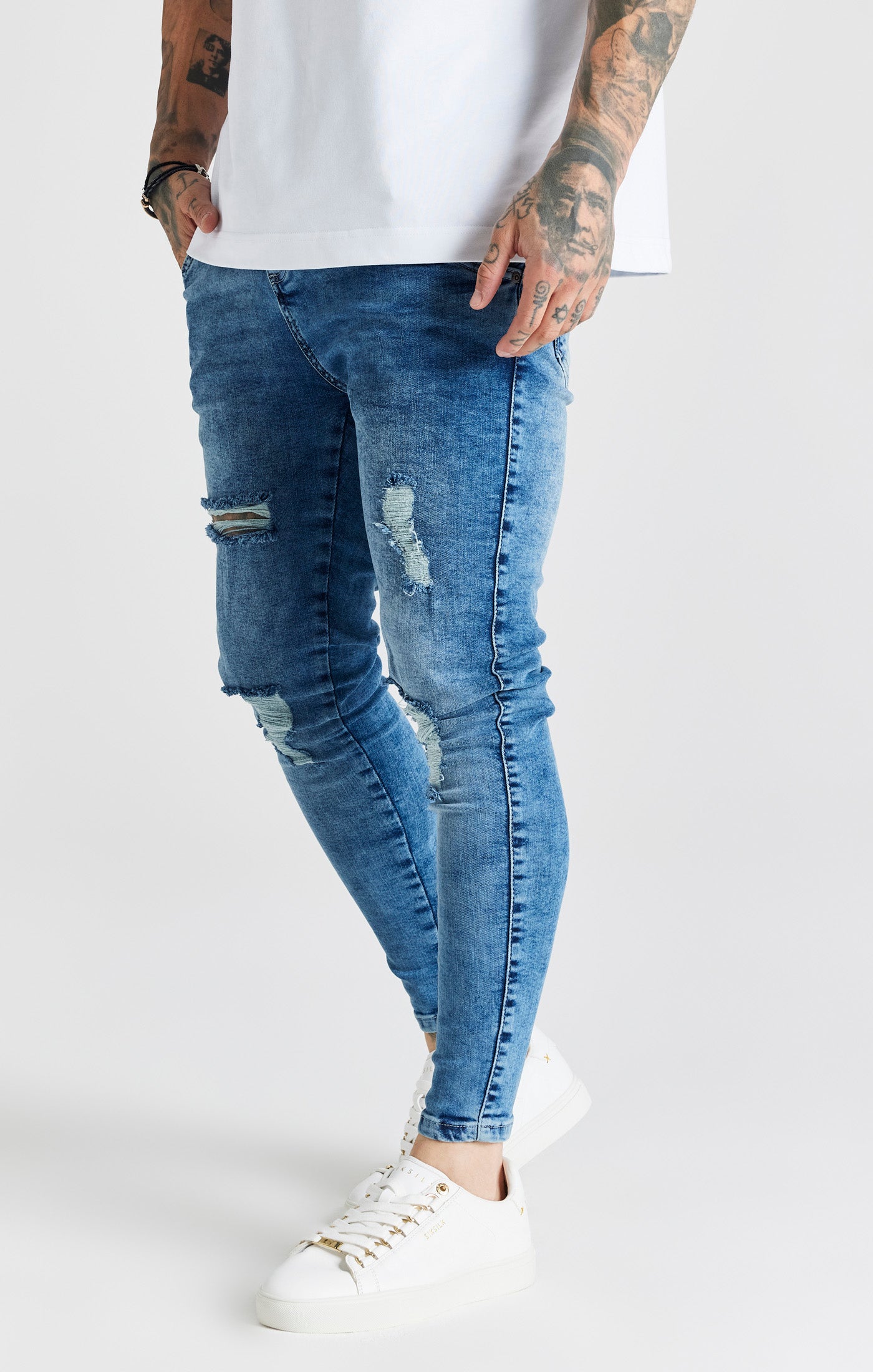 Laad de afbeelding in de Galerij viewer, Essentials - Blauwe half verwassen skinny jeans met een gedragen look en versleten details