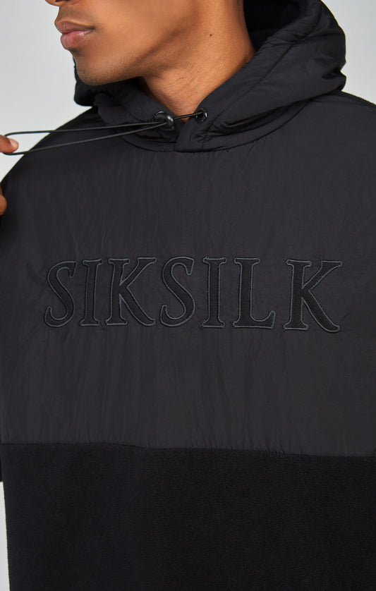 Zwarte sweater met capuchon van polar fleece afgewerkt met knip- en naaitechniek